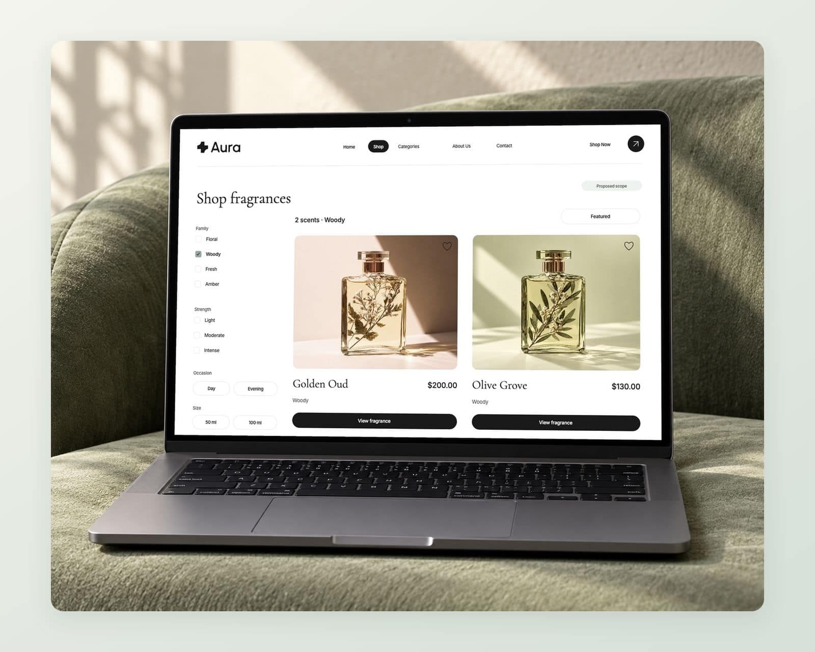 Aura’s shop page with family, strength, occasion and size filters, Woody selected in aqua, and Golden Oud at $200.00 and Olive Grove at $130.00 in the results