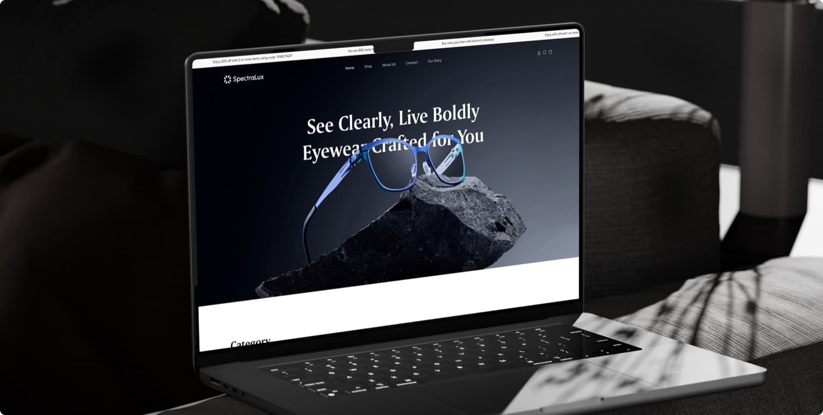 The SpectraLux website on a laptop, with the headline See Clearly, Live Boldly over a pair of blue glasses resting on a rock