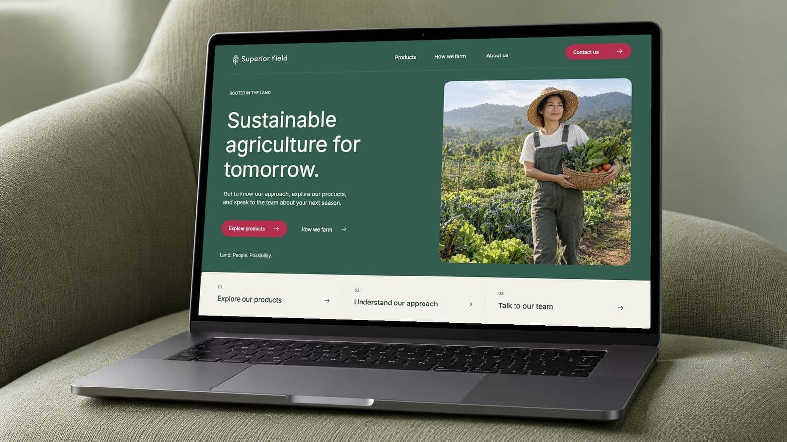 Superior Yield homepage concept on a graphite laptop resting on a sage upholstered chair