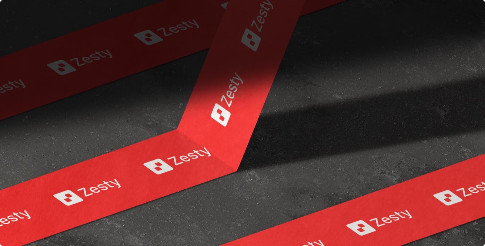 Red tape printed with the Zesty mark and wordmark, laid across a dark floor