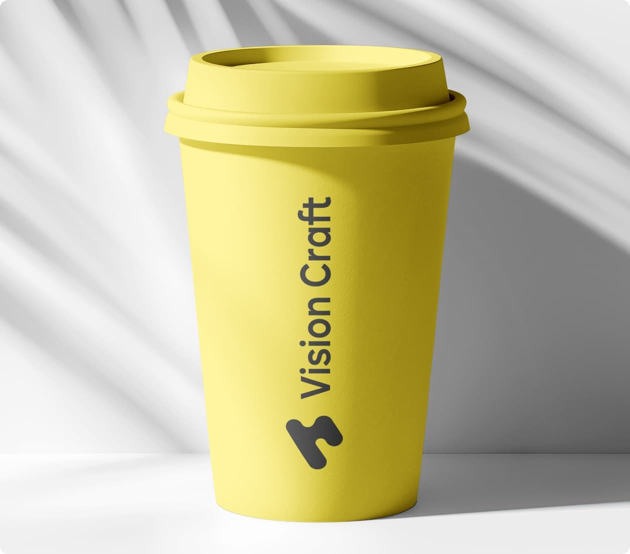 A yellow paper cup carrying the Vision Craft mark and wordmark