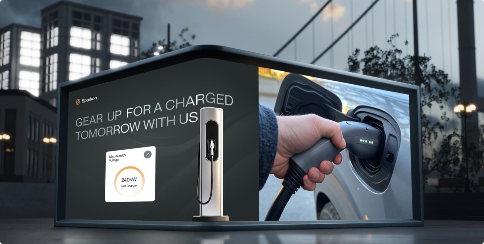 A Sparkon billboard at dusk, with the headline Gear Up for a Charged Tomorrow With Us, a charging station and a hand plugging a charger into a car