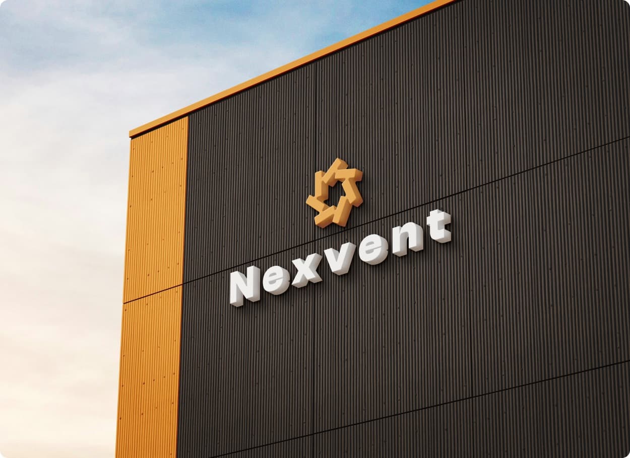 The Nexvent mark in orange and the wordmark in white raised letters on the dark cladding of a building