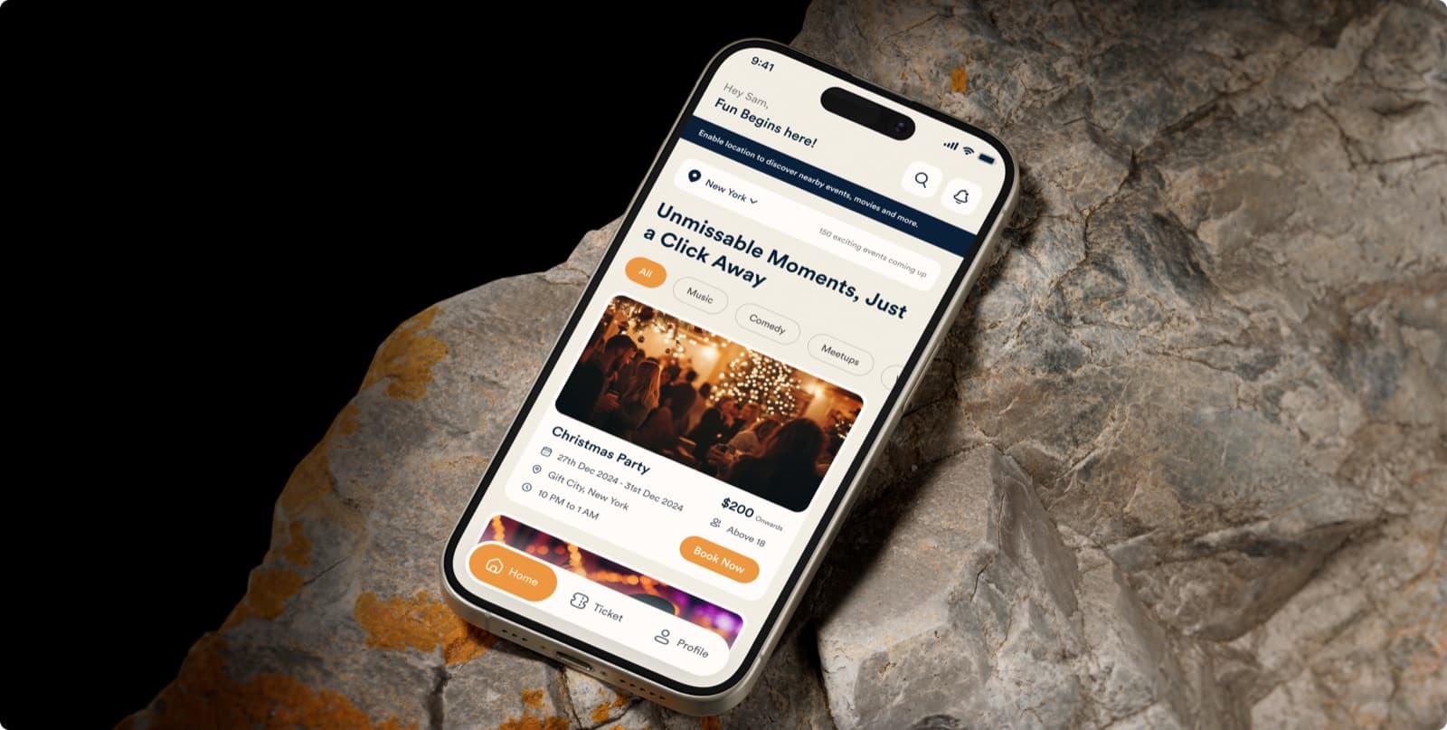 The Nexvent app on a phone resting on a rock, with the headline Unmissable Moments, Just a Click Away above an event card for a Christmas party