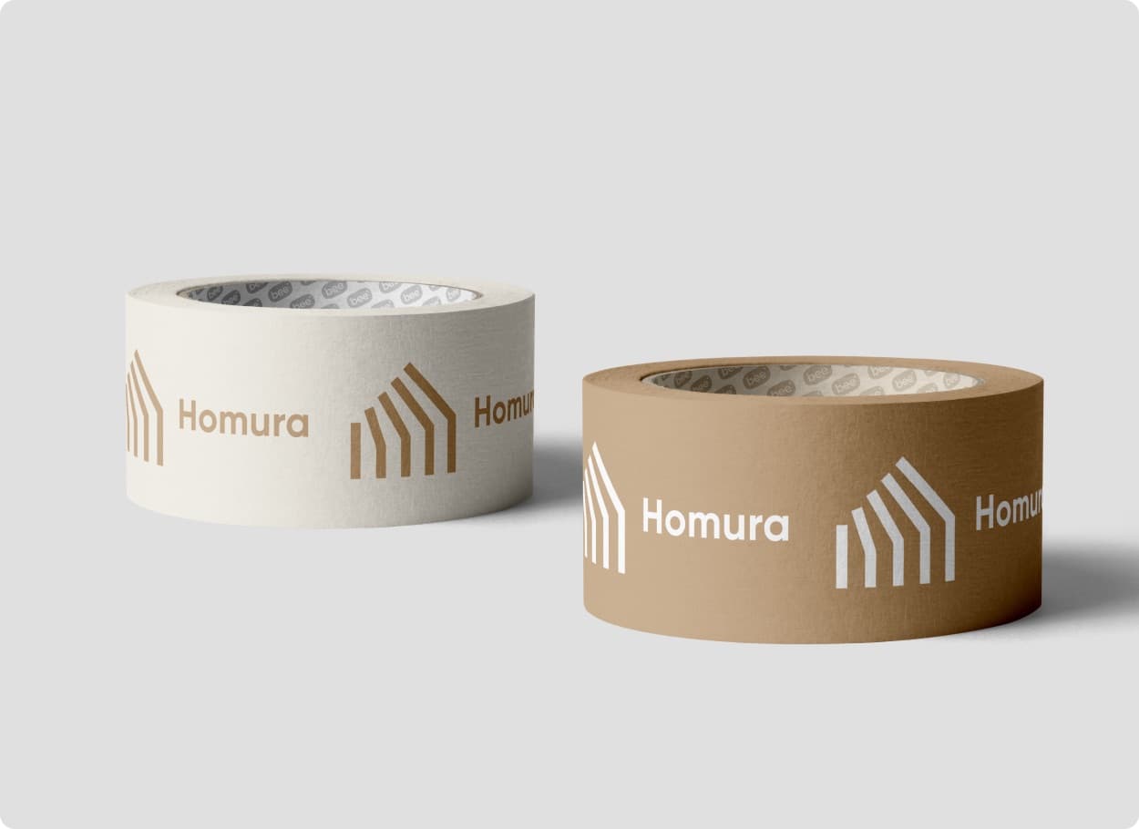 Two rolls of packing tape, one cream and one brown, printed with the Homura mark and name