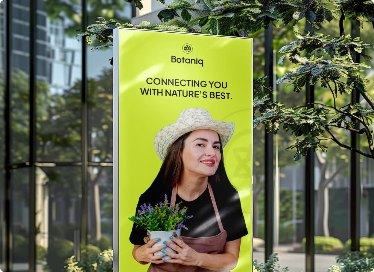 A lime green street poster with the Botaniq mark, the headline Connecting You With Nature’s Best and a woman holding a potted plant