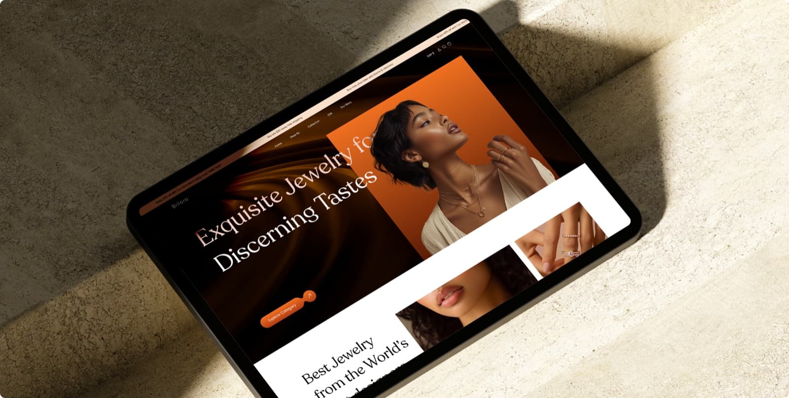 The Brilora homepage on a tablet lying on stone, with the headline Exquisite Jewelry for Discerning Tastes