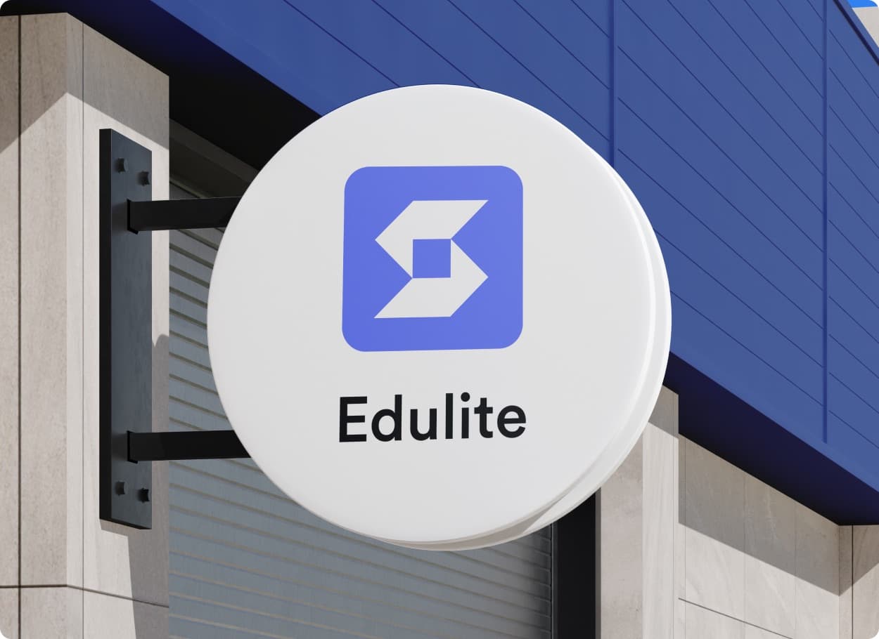 The Edulite mark and wordmark on a round white sign fixed to a building