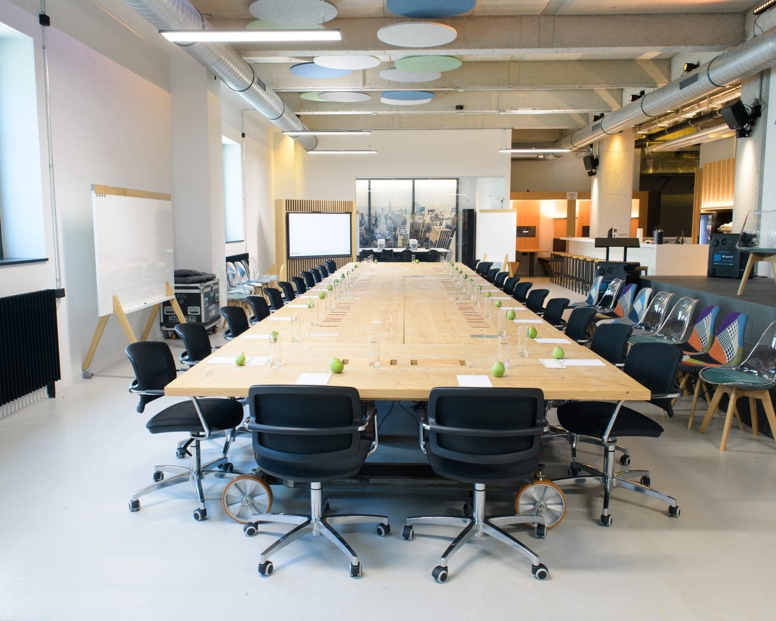 The real Pawrti conference space with a long meeting table, seating, projection screen and bar