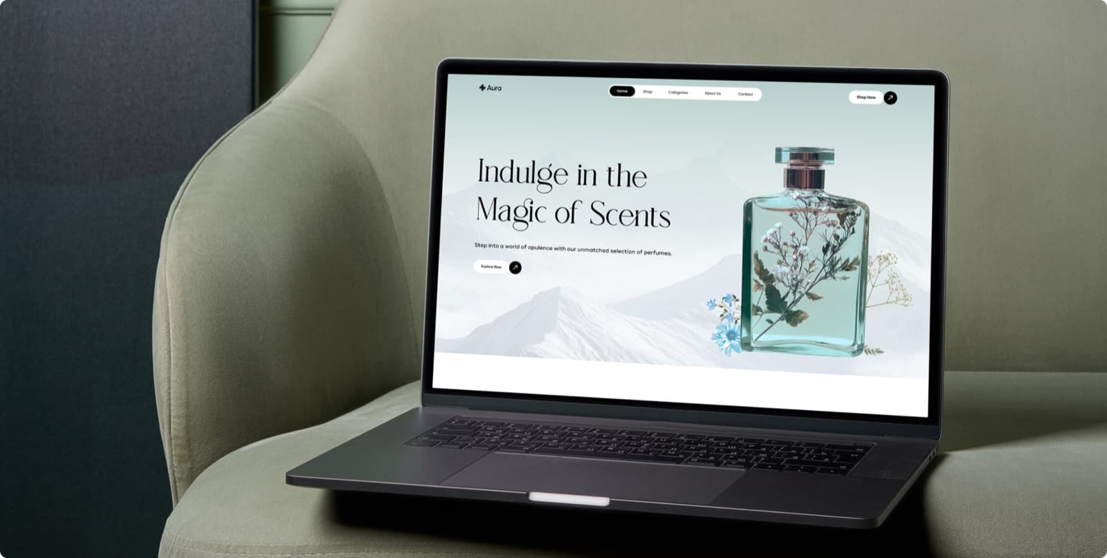 The Aura perfume website on a laptop, with the headline Indulge in the Magic of Scents beside a perfume bottle