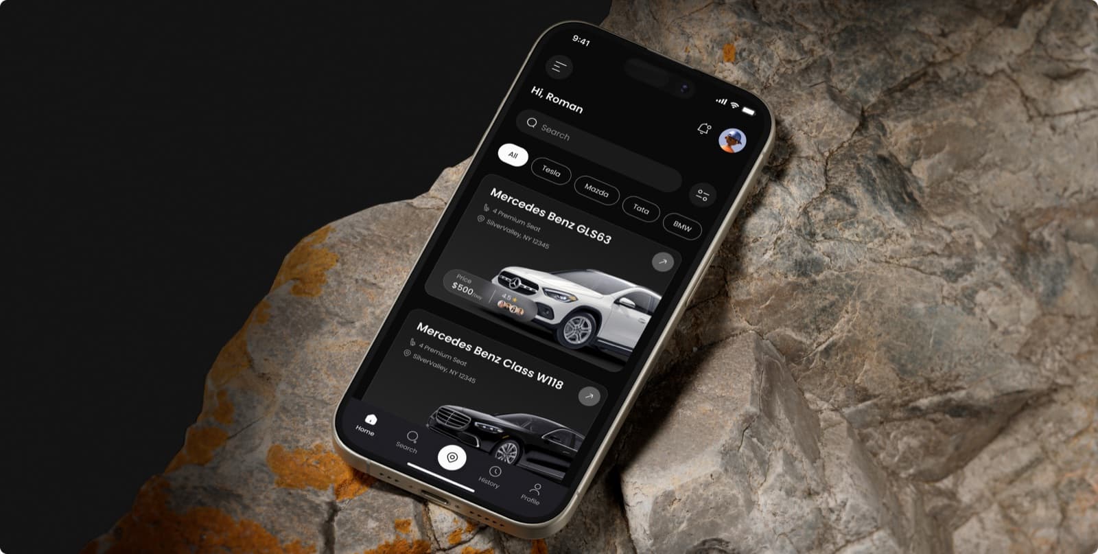 The Rentease car rental app on a phone resting on rock, showing a search bar, a row of filters and two cars with a price per day