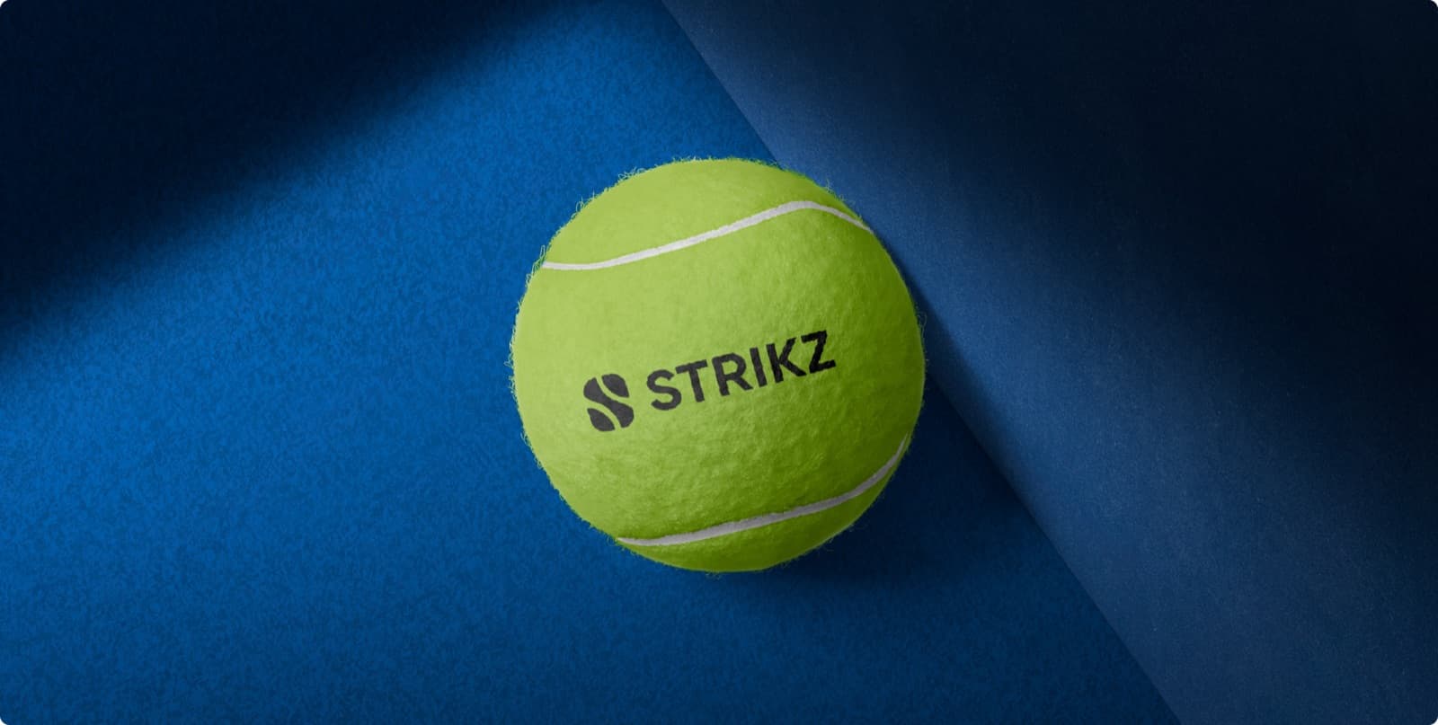 A tennis ball printed with the Strikz mark and wordmark, on a blue court surface