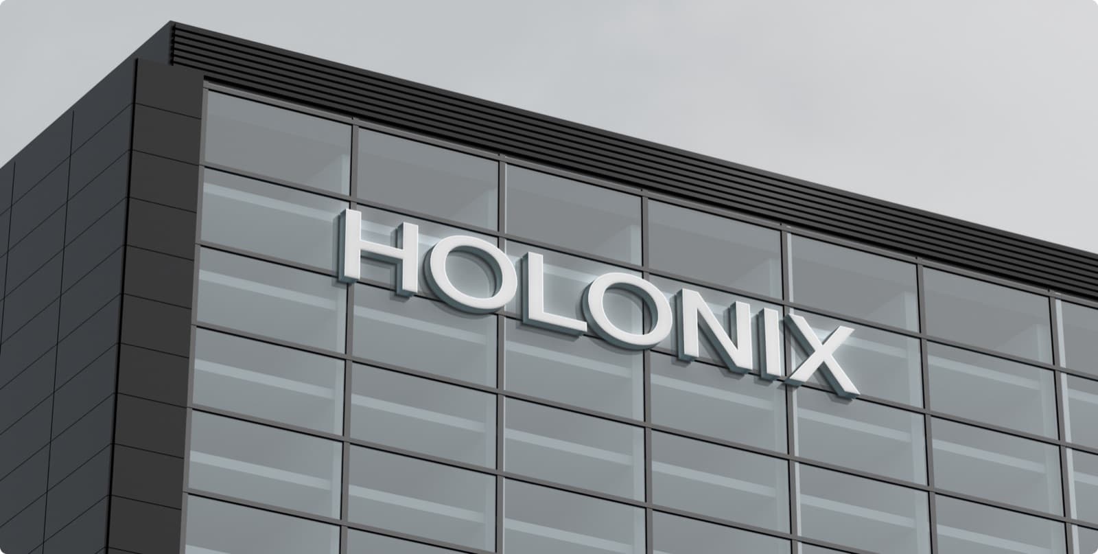 The Holonix wordmark as raised white letters on the glass front of a dark building