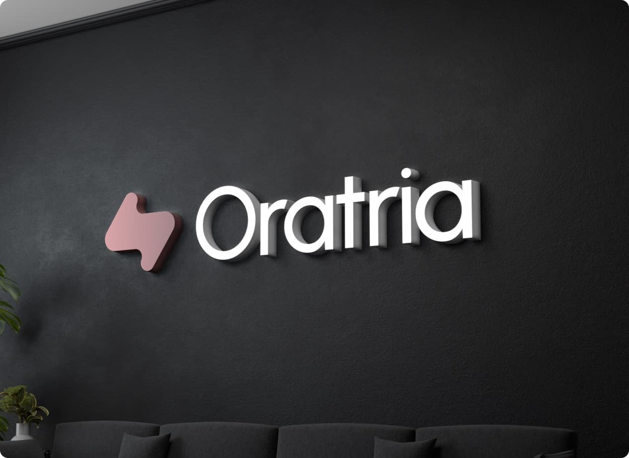 The Oratria mark in rose and the wordmark in white raised letters on a dark wall above a sofa