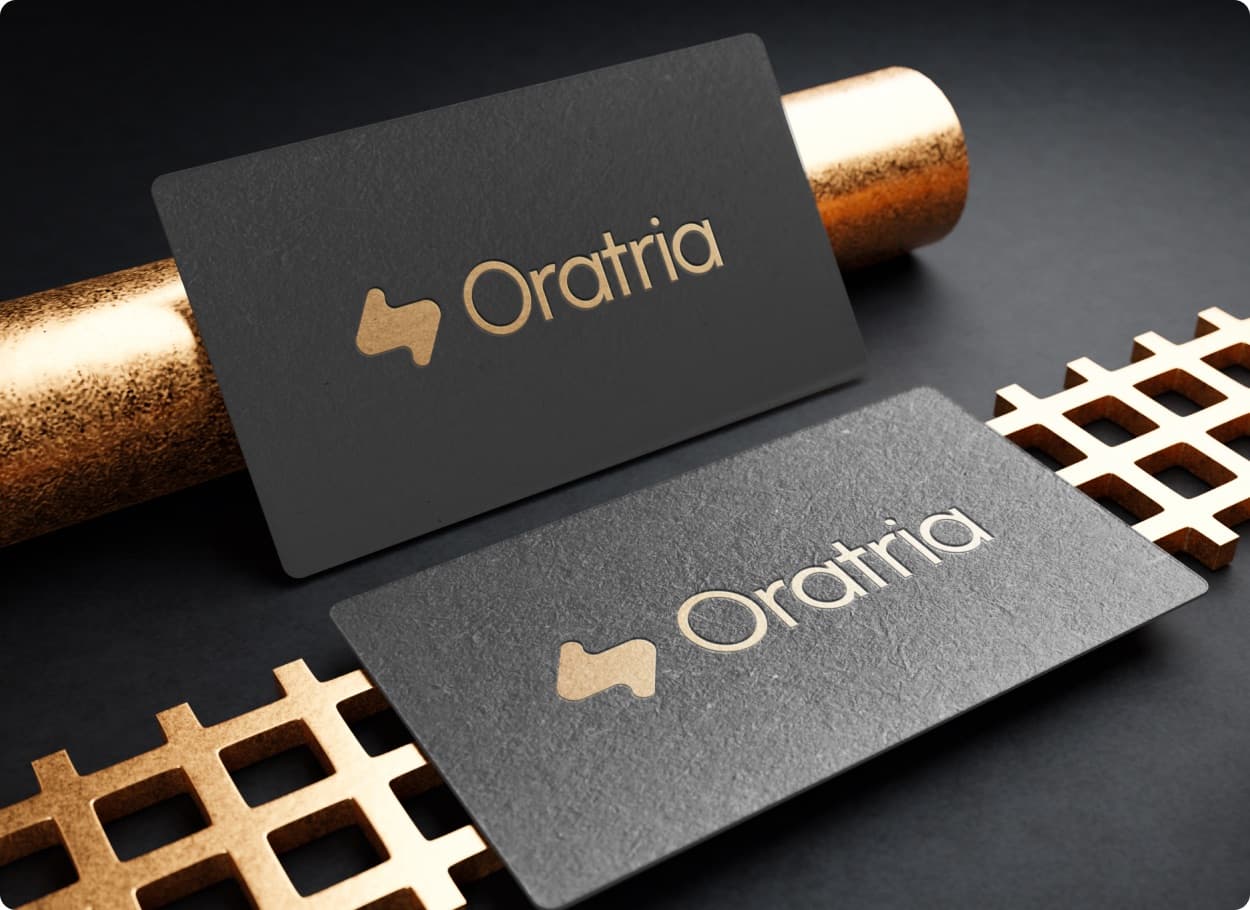 Two black business cards with the Oratria mark and wordmark in gold